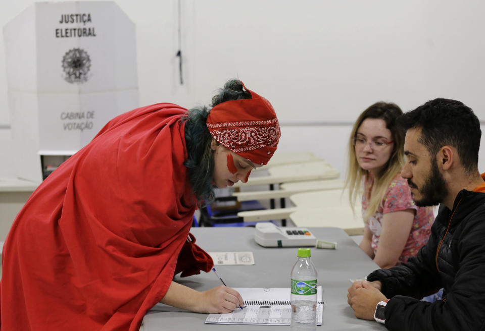A woman prepares to vote in the presidential runoff election in Sao Paulo, Brazil, Sunday, Oct. 28, 2018. Brazilian voters decide who will next lead the world's fifth-largest country, the left-leaning Fernando Haddad or far-right rival Jair Bolsonaro. (AP Photo/Nelson Antoine)