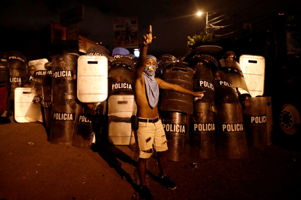 <p>A supporter of Salvador Nasralla, presidential candidate for the Opposition Alliance Against the Dictatorship, gestures in front of riot police while he waits for official presidential election results outside the warehouse of the Supreme Electoral Tribunal in Tegucigalpa, Honduras, Nov. 30, 2017. (Photo: Edgard Garrido/Reuters) </p>