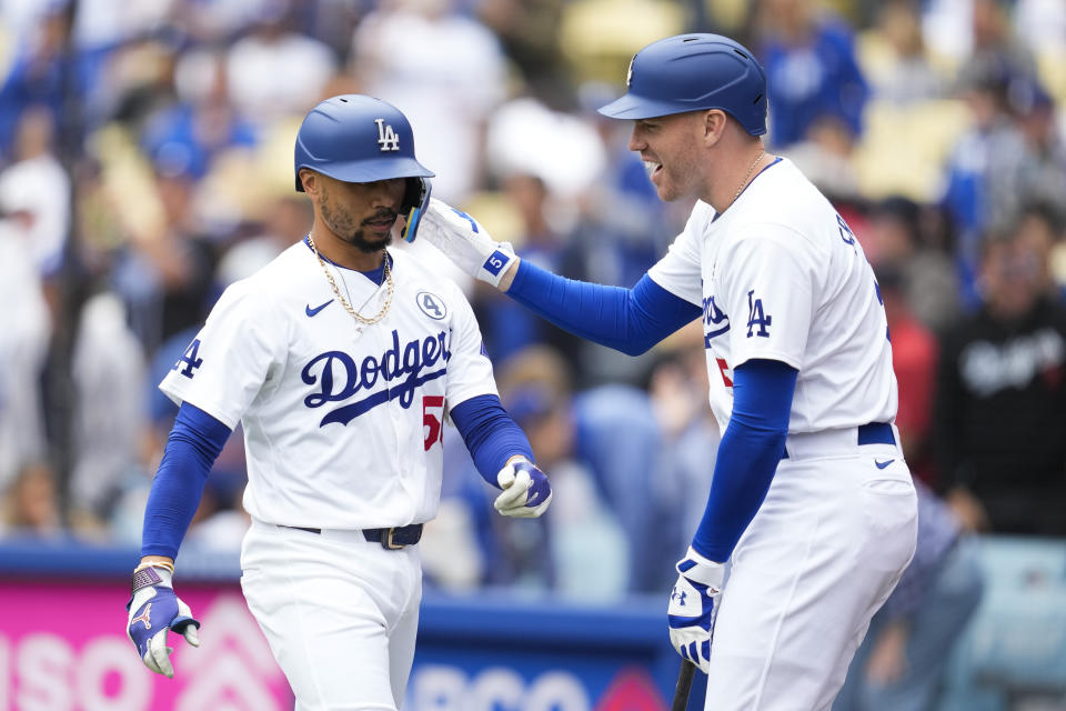 Los Angeles Dodgers' Mookie Betts (50) celebrates with Freddie Freeman, right, after hitting a home run during the first inning of a baseball game against the Colorado Rockies in Los Angeles, Sunday, June 2, 2024. (AP Photo/Ashley Landis)