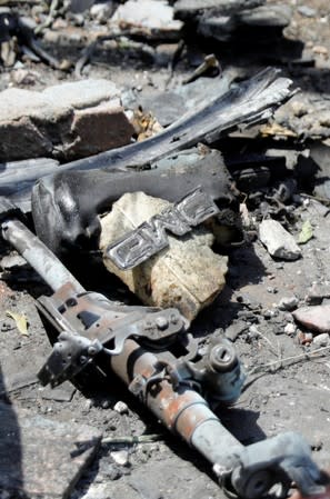 Belongings of victims are seen amid rubble in front of the damaged facade of the National Cancer Institute after an overnight fire from a blast, in Cairo