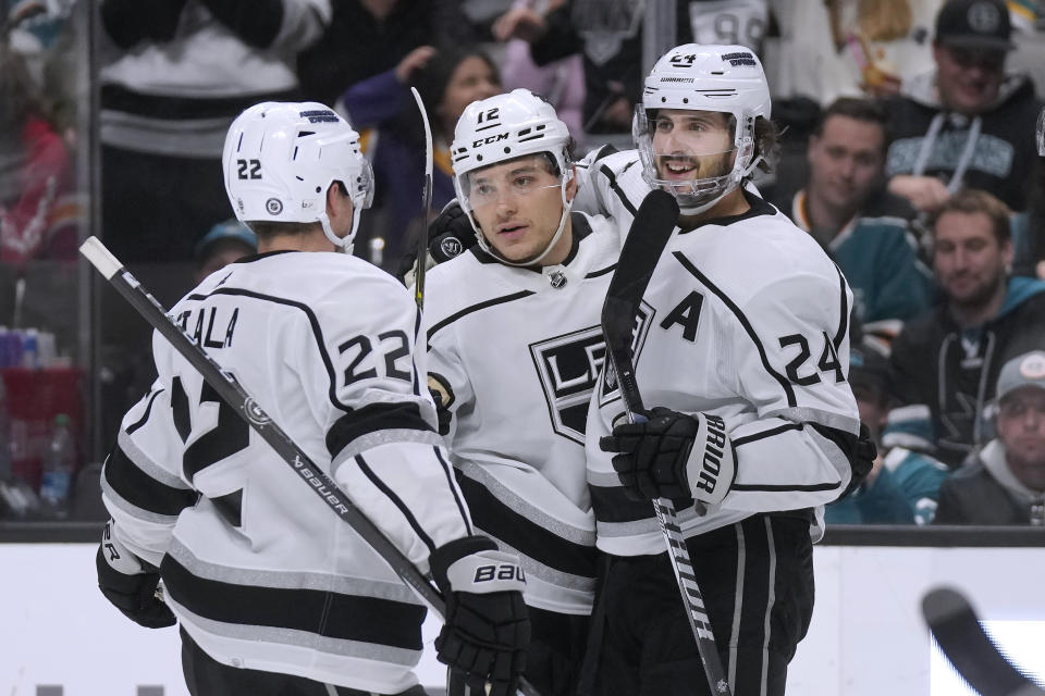 Los Angeles Kings left wing Trevor Moore, middle, is congratulated by left wing Kevin Fiala (22) and center Phillip Danault (24) after scoring against the San Jose Sharks during the second period of an NHL hockey game in San Jose, Calif., Tuesday, Dec. 19, 2023. (AP Photo/Jeff Chiu)