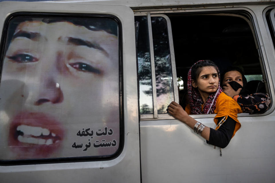 A young woman and an older woman looks out of a van window.