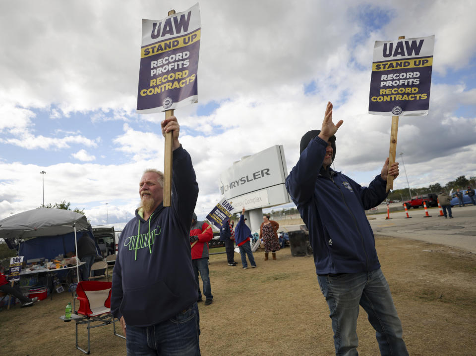 File - Striking United Auto Workers members Rob Marchese, left, and Neil Peters picket at the Stellantis Toledo Assembly Complex on Oct. 7, 2023, in Toledo, Ohio. The UAW contends that the furloughs by Detroit's three automakers were not necessary and are being done in an effort to push members to accept less in contract negotiations. (Kurt Steiss/The Blade via AP, File)