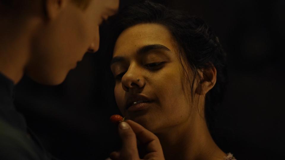 Close-up on Rand, with a berry in his fingers, offering to feed it to Egwene