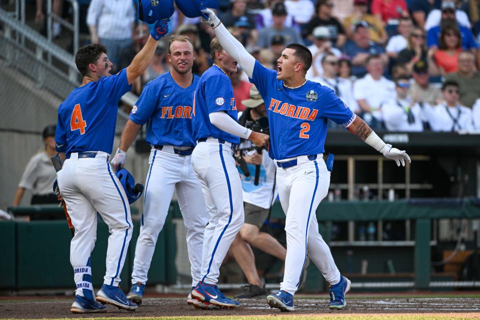 Jun 18, 2023; Omaha, NE, USA;  Florida Gators outfielder Ty Evans (2) celebrates with second baseman Cade Kurland (4) and teammates after hitting a home run against the Oral Roberts Golden Eagles in the second inning at Charles Schwab Field Omaha. Mandatory Credit: Steven Branscombe-USA TODAY Sports