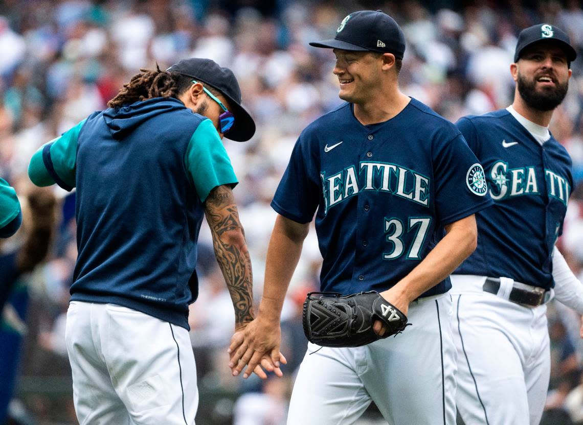 Seattle Mariners relief pitcher Paul Sewald (37) high-fives Seattle Mariners shortstop J.P. Crawford (3) as he walks off the field after defeating the New York Yankees 4-3 to win their first season series finale against the Yankees in 20 years, after the game at T-Mobile Park in Seattle, Wash. on August 10, 2022.