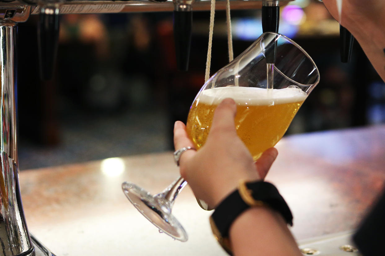 MANCHESTER, ENGLAND - JULY 19: A member of staff pours a pint for a customer at Wetherspoons pub The Moon Under Water on July 19, 2021 in Manchester, England. As of 12:01 on Monday, July 19, England will drop most of its remaining Covid-19 social restrictions, such as those requiring indoor mask-wearing and limits on group gatherings, among other rules. These changes come despite rising infections, pitting the country's vaccination programme against the virus's more contagious Delta variant. (Photo by Charlotte Tattersall/Getty Images)