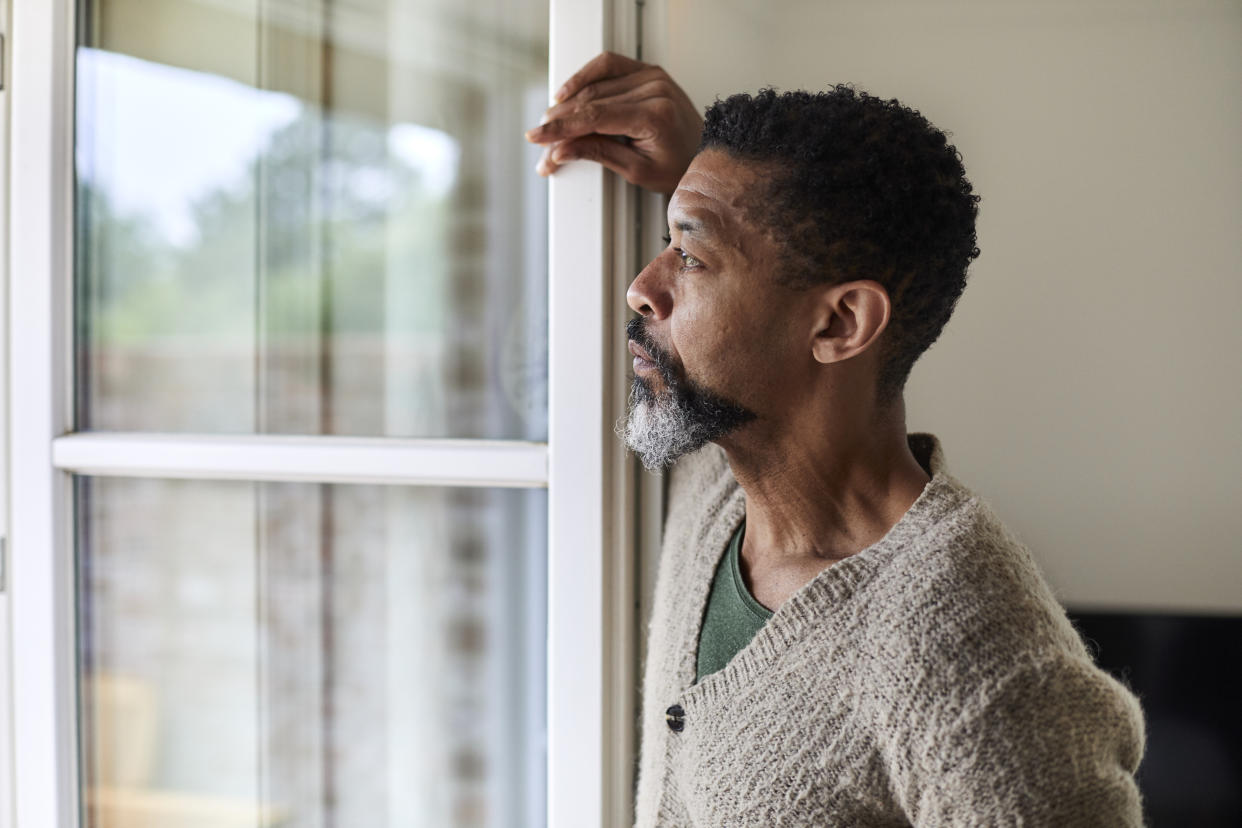 Loneliness: man looking out the window. (Getty Images)