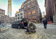 Jean Ryan, president of the advocacy group Disabled In Action, leaves a car service for disabled individuals to transport after a ride from her home in Brooklyn to Manhattan, Wednesday, Feb. 7, 2024, in New York. The Big Apple is close to implementing a plan that would use license-plate readers to turn all of Manhattan south of Central Park into one giant toll zone. (AP Photo/Bebeto Matthews)