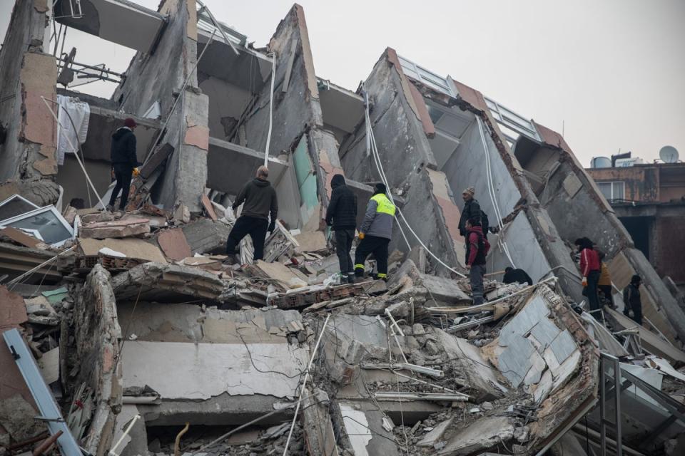 People try to rescue their loved ones, believed to be trapped under collapsed building, in Iskenderun, Turkey (Getty Images)