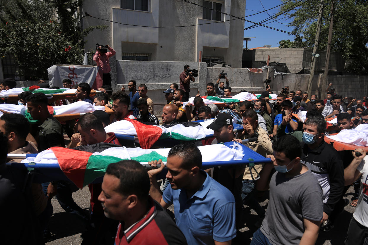Un grupo de palestinos cargan los cuerpos de varios niños asesinados en un ataque aéreo israelí en la ciudad de Gaza, en la Franja de Gaza, el sábado 15 de mayo de 2021. (Samar Abu Elouf/The New York Times)