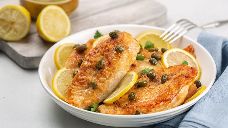 chicken with lemon and capers on a white dish