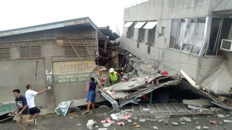 Rescue crew members look for trapped victims at collapsed building at Padada market, in Padada