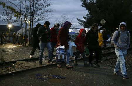 Migrants walk past rail tracks after crossing the border from Greece into Macedonia, near Gevgelija, Macedonia, November 27, 2015. REUTERS/Stoyan Nenov