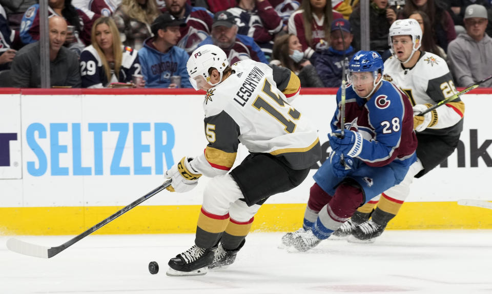 Vegas Golden Knights center Jake Leschyshyn, left, struggles to control the puck as Colorado Avalanche defenseman Ryan Murray pursues in the second period of an NHL hockey game Tuesday, Oct. 26, 2021, in Denver. (AP Photo/David Zalubowski)