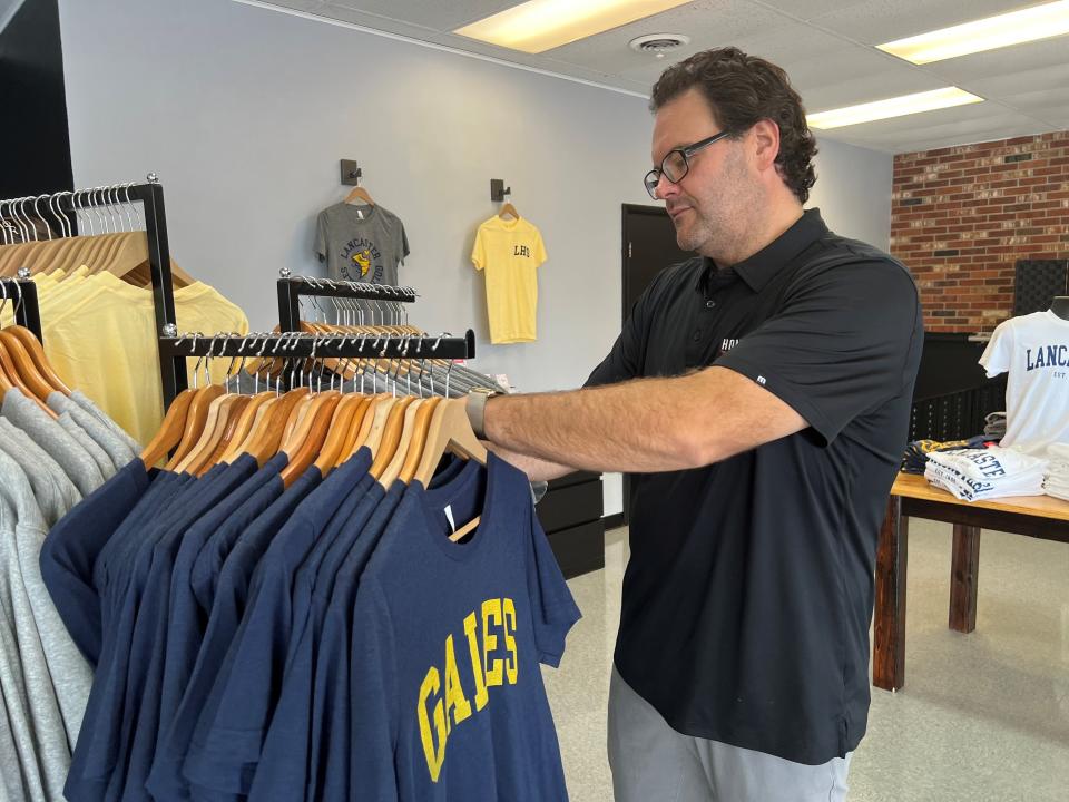 Hometown Apparel Screen Printing and Embroidering co-owner Ben Thompson arranges Lancaster High School t-shirts at the new business at 1122 N. Memorial Drive.