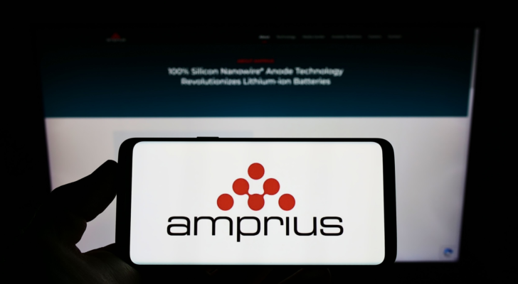 Person holding mobile phone with logo of American company Amprius Technologies (AMPX) Inc. on screen in front of web page. Focus on phone display. Unmodified photo.