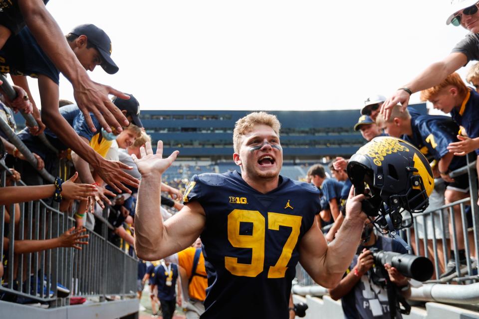 Aidan Hutchinson high-fives fans after the Wolverines' 47-14 win over Western Michigan at Michigan Stadium on Sept. 4, 2021.