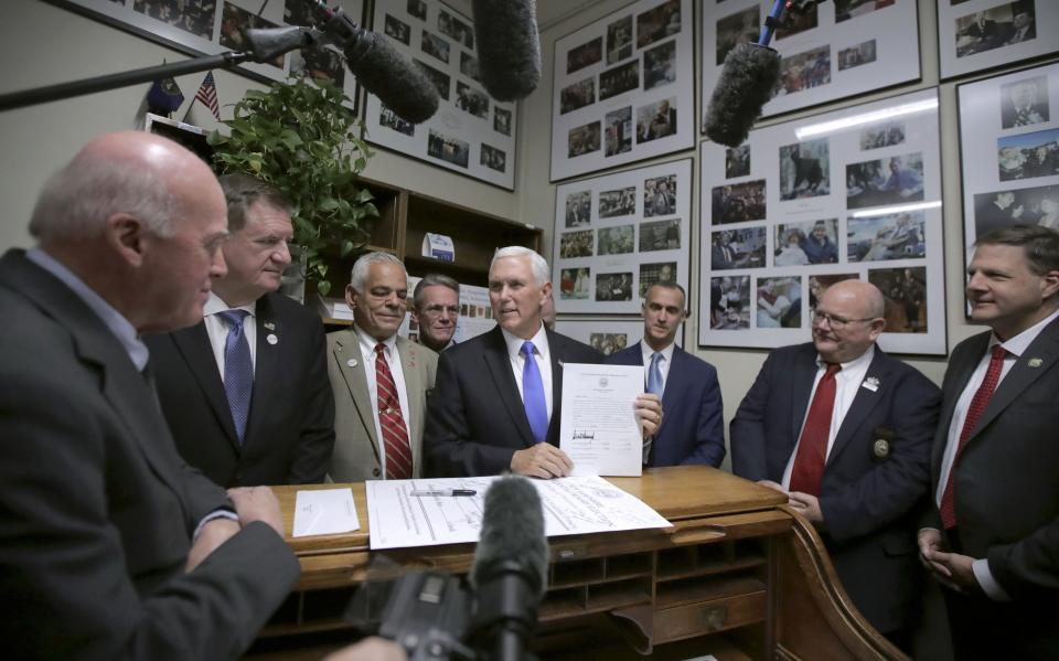 Republican Vice President Mike Pence, center, speaks to Secretary of State Bill Gardner, left, as Pence files for President Donald Trump to be listed on the New Hampshire primary ballot, Thursday, Nov. 7, 2019, in Concord, N.H. At right is New Hampshire Gov. Chris Sununu, (AP Photo/Charles Krupa)