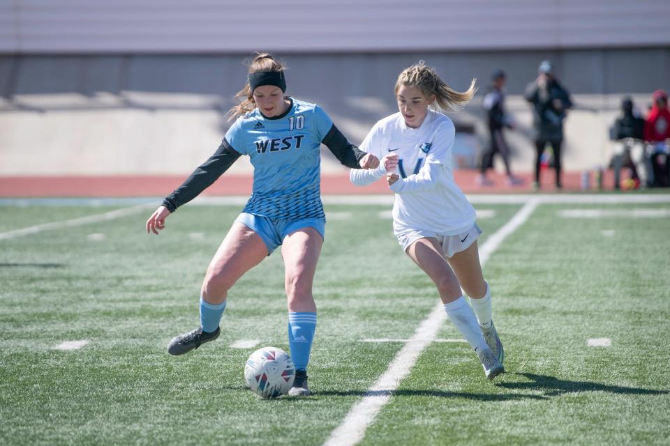 Pueblo West's Kaitlyn Peterson wins a battle for possession over a Riverdale Ridge defender during a matchup at Cyclone Stadium on Saturday, March 25, 2023.