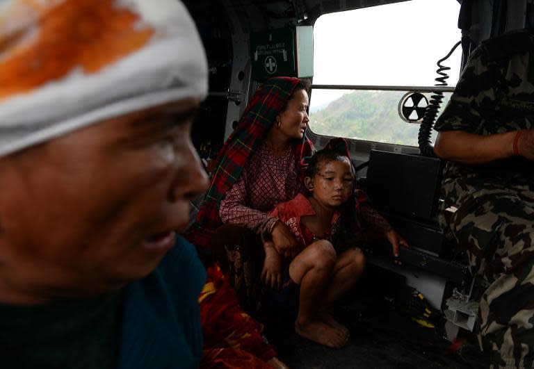 Nepalese villagers injured in an earthquake sit inside an Indian Army helicopter after being evacuated from Lapu in Gorkha on April 28, 2015