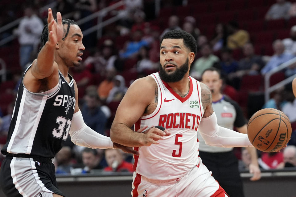 Houston Rockets' Fred VanVleet (5) looks to pass the ball as San Antonio Spurs' Tre Jones (33) defends during the first half of an NBA basketball game Tuesday, March 5, 2024, in Houston. (AP Photo/David J. Phillip)