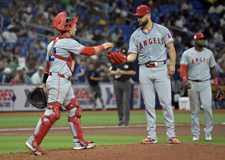 Los Angeles Angels catcher Matt Thaiss, left, walks to the mound to talk with starter Patrick Sandoval, center, during the fifth inning of a baseball game against the Tampa Bay Rays Monday, April 15, 2024, in St. Petersburg, Fla. (AP Photo/Steve Nesius)