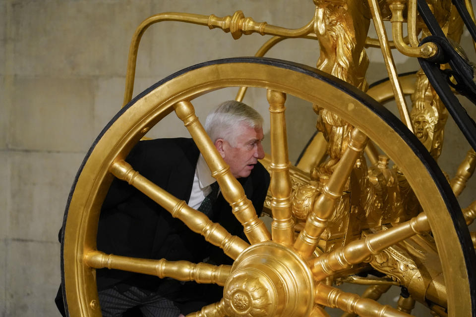 Britain's Speaker of the House of Commons Lindsay Hoyle walks around the Speaker's State Coach as it returns to Westminster, ahead of the coronation of Britain's King Charles III, in London, Sunday, April 30, 2023. The gilded coach, which was last seen in the historic Westminster Hall in 2005, will be on display once again from 2 May to the Autumn, to commemorate the crowning of King Charles III. (AP Photo/Alberto Pezzali)