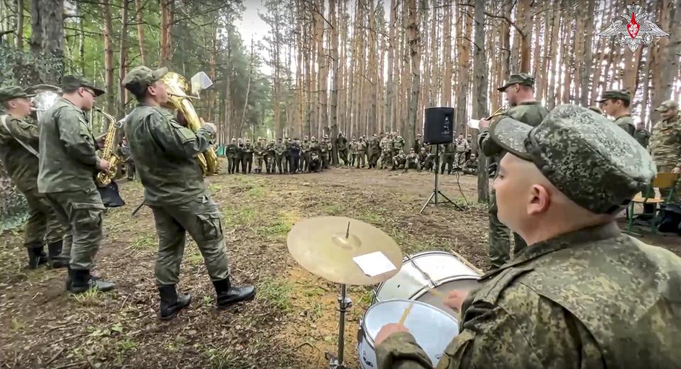 In this image made from undated video released by Russian Defense Ministry Press Service on Sunday, June 11, 2023, artists of the Ural Brass Band and the Front Brigade of the Song and Dance Ensemble of the Central Military District perform during a concert at the advanced area of the special operation at an undisclosed location.(Russian Defense Ministry Press Service via AP)