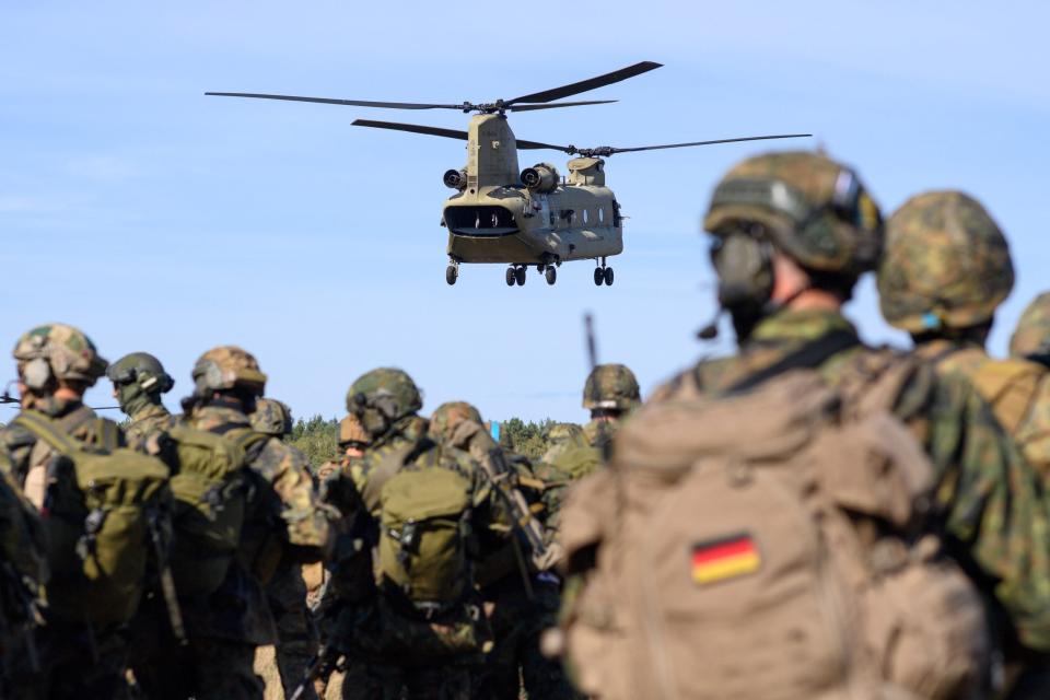 Bundeswehr-Soldaten des Falschirmjägerregiments warten auf die Landung eines Chinook C-47 Hubschraubers der US-Army, der die Soldaten aufnehmen soll.  - Copyright: picture alliance/dpa/dpa-Zentralbild | Klaus-Dietmar Gabbert
