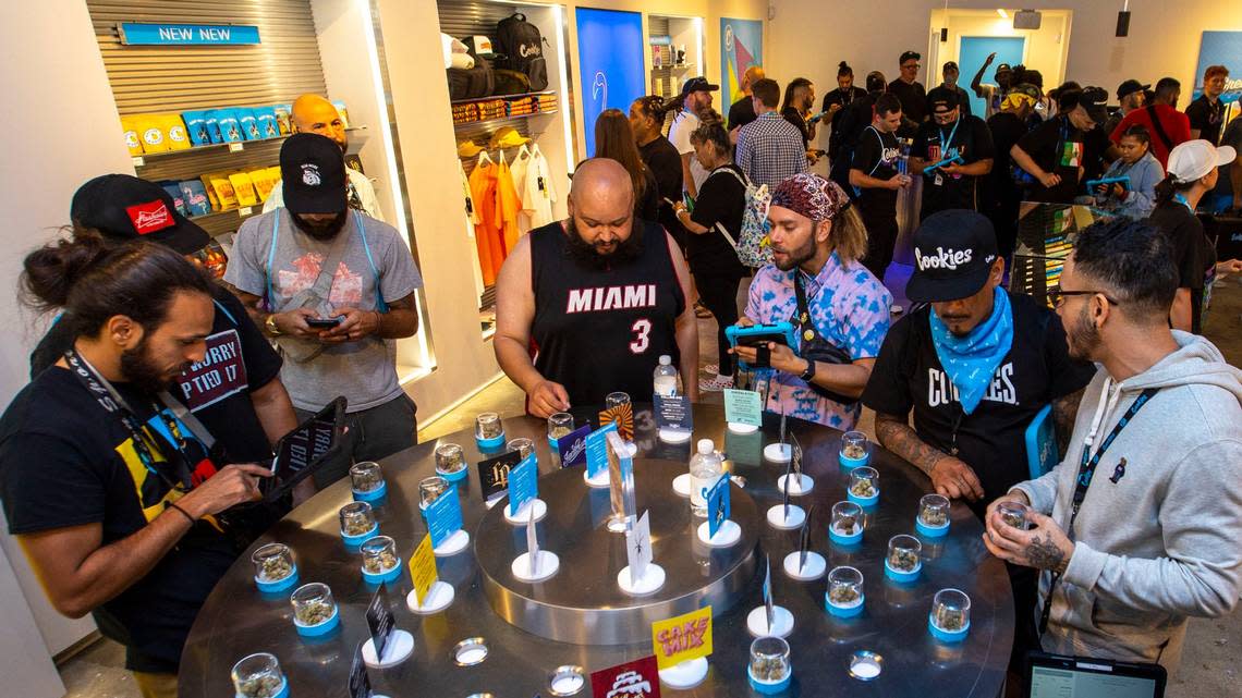 Customers and budtenders look over different strains of marijuana during the grand opening of Cookies Miami, Florida’s first and only minority-owned marijuana dispensary, in Miami, Florida, on Saturday, August 13, 2022. Palenzuela got in line thursday at 2 in the morning.