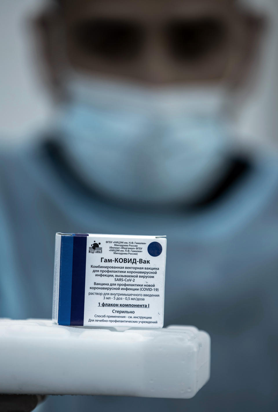 A Palestinian medic displays a box of one of 20,000 doses of Russian-made Sputnik V vaccine upon its arrival to Gaza Strip, at the Rafah crossing border with Egypt, Sunday, Feb. 21, 2021. The 20,000 doses of Russia's Sputnik V, donated by the United Arab Emirates and organized by Abbas rival Mohammed Dahlan, entered the Palestinian enclave through its border with Egypt. (AP Photo/Khalil Hamra)