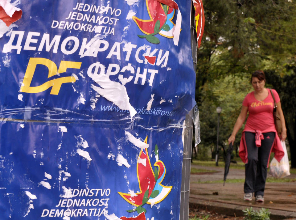 A woman passes by main opposition Democratic Front election poster reading "Unity, Equality, Democracy - Democratic Front", in downtown Podgorica, Montenegro, Friday, Oct. 12, 2012, two days ahead of parliamentary elections scheduled for upcoming October 14. Montenegro’s ruling coalition of longtime leader Milo Djukanovic is again a favorite to win weekend parliamentary elections in the tiny Balkan nation seeking membership in the European Union. (AP Photo/Risto Bozovic)