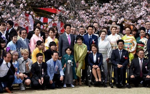 Abe and his wife Akie posing with entertainers and athletes during the cherry blossom viewing party in April 2017 - Credit: TORU YAMANAKA/AFP