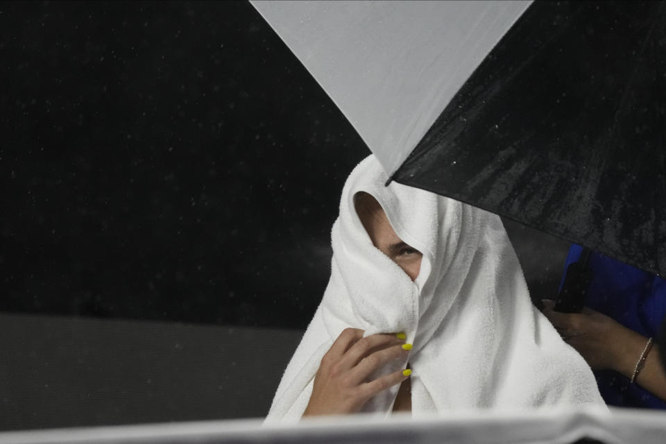 Aryna Sabalenka, of Belarus, takes cover from the rain during a women's singles match against Elena Rybakina, of Kazakhstan, at the WTA Finals tennis championships, in Cancun, Mexico, Thursday, Nov. 2, 2023. (AP Photo/Fernando Llano)