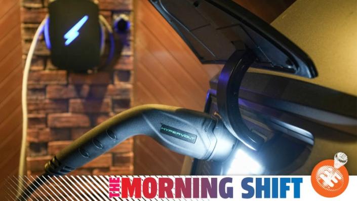 A photo of the charging plug of an EV as it charges, with the Jalopnik &quot;Morning Shift&quot; banner overlaid.