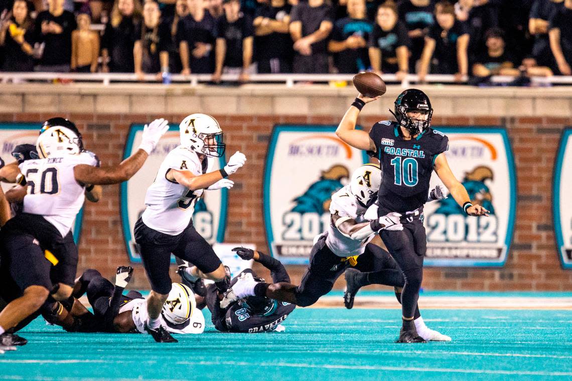 Coastal’s Grayson McCall passes under pressure from App State. The Coastal Carolina Chanticleers beat rival Appalachian State 35-28 in front of a record crowd at Brooks Stadium Thursday night. November 3, 2022.