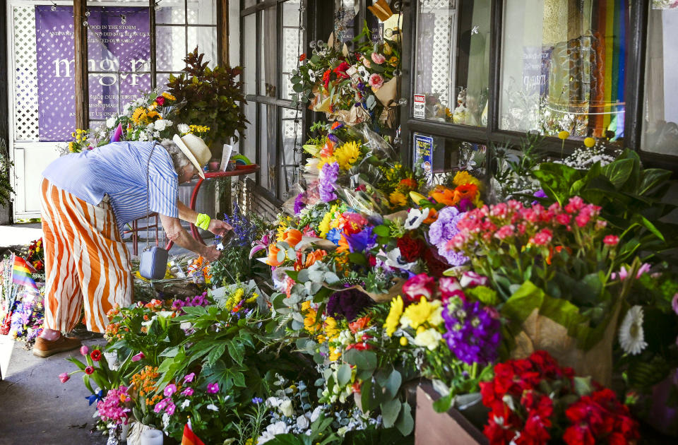 Cedar Glen community member Trish Forest leaves flowers for Laura Ann "Lauri" Carleton outside Mag.Pi, the store she owned and operated, on Tuesday, Aug. 22, 2023. Carleton was shot outside of her clothing store on Friday, Aug. 18, by a man who had ripped down an LGBTQ+ Pride flag outside the business and shouted homophobic slurs at her. (Anjali Sharif-Paul/The Orange County Register via AP)