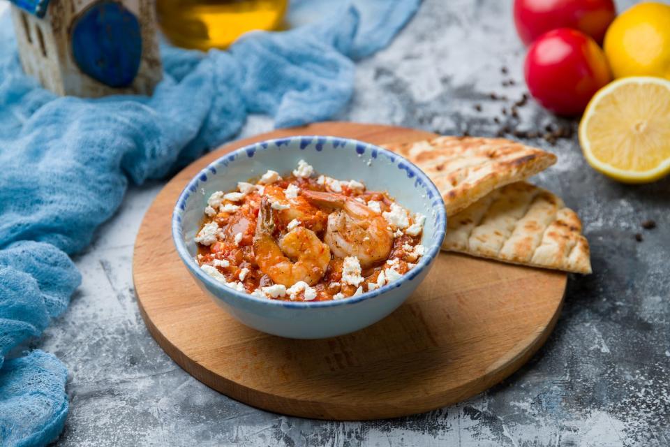 Dieses schnelle Gericht kann je nach Belieben als Vor- oder Hauptspeise gereicht werden. Dazu brät man Garnelen mit Zitronensaft, Knoblauch und Ouzo an, bis der Alkohol verdampft ist. Nun wird eine reichhaltige Tomatensauce gekocht und mit den Meerestieren und Fetakäse im Ofen etwa 15 Minuten gegrillt. (Bild: iStock / Максим Крысанов)