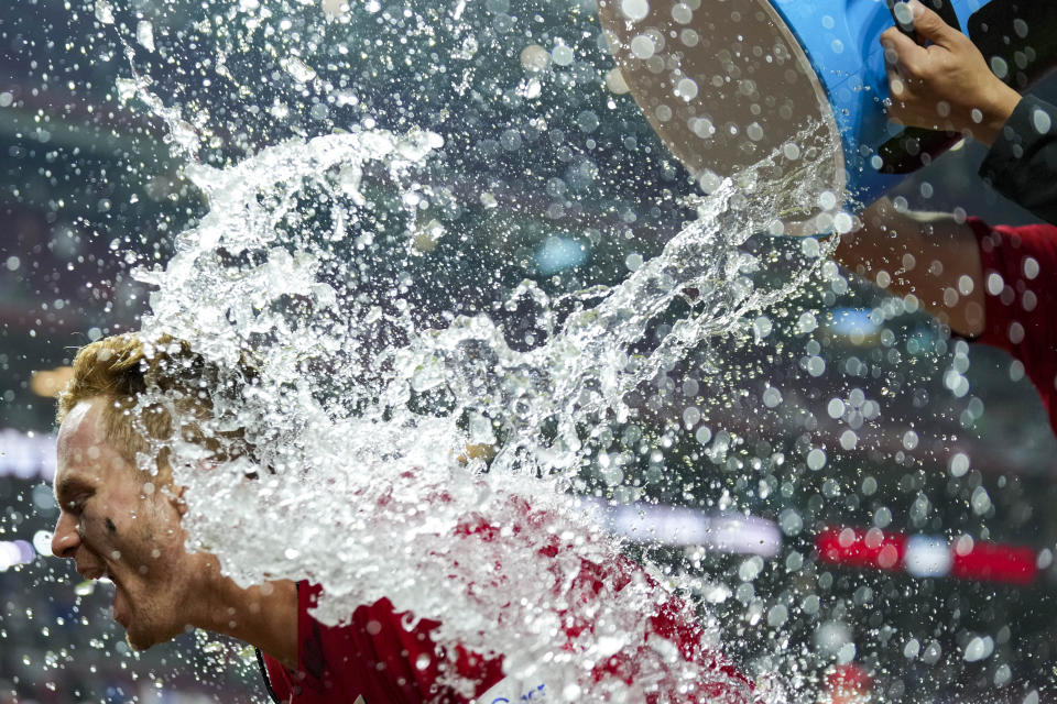 Cincinnati Reds' Matt McLain is doused by teammates after driving in the winning run against the Los Angeles Dodgers during the ninth inning of a baseball game in Cincinnati, Tuesday, June 6, 2023. (AP Photo/Aaron Doster)