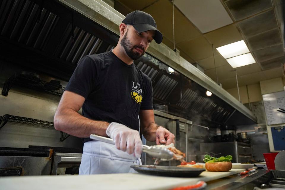 Lino Santos prepares a smoked turkey sandwich at The Local in Naples on Tuesday, April 11, 2023.