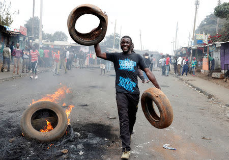 A supporter of opposition leader Raila Odinga gestures in front of burned barricade in Kibera slum in Nairobi, Kenya, August 11, 2017. REUTERS/Goran Tomasevic