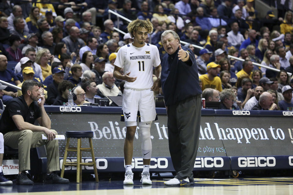 West Virginia coach Bob Huggins speaks with West Virginia forward Emmitt Matthews Jr. (11) after a play during the second half of an NCAA college basketball game Monday, Jan. 20, 2020, in Morgantown, W.Va. (AP Photo/Kathleen Batten)