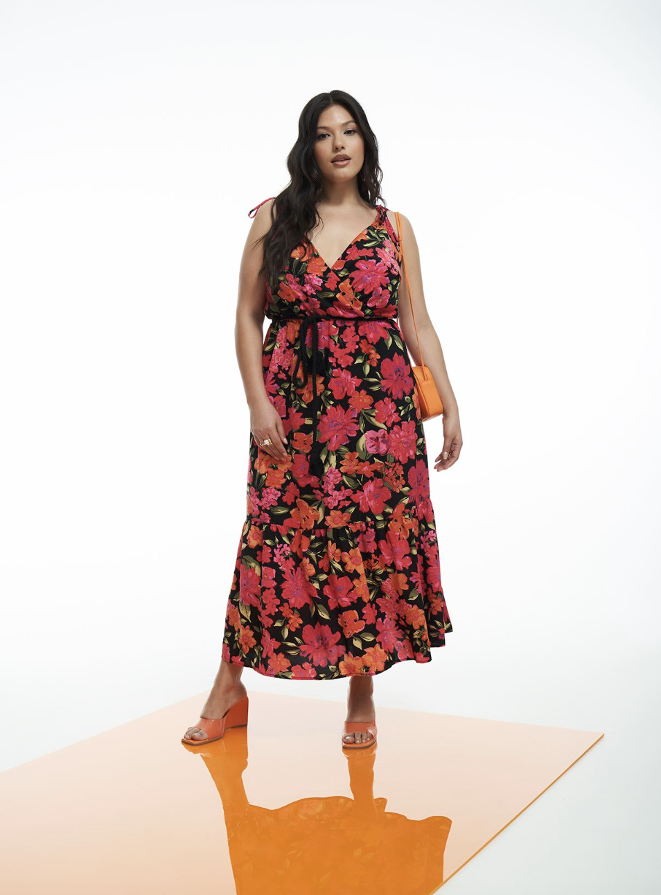 plus size model wearing pink and black floral Floral Woven Tiered Maxi Dress (photo via Penningtons)