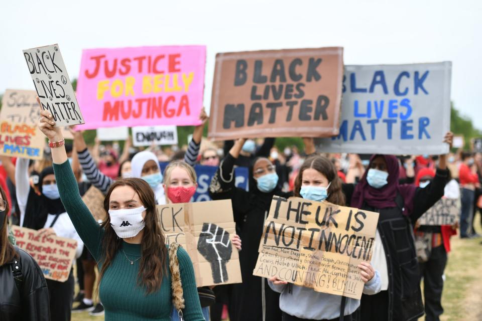 Protesters holding placards (PA)