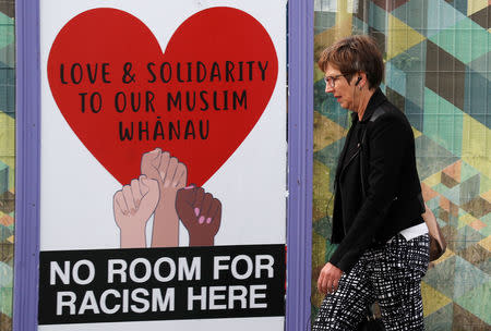 A woman walks past posters after last Friday's mosque attacks in Christchurch, New Zealand March 21, 2019. REUTERS/Jorge Silva