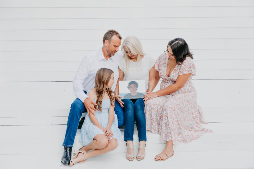 Melissa and Peter McGuinness and their two daughters gather around a photo of Jordan.