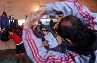 In this Wednesday, March, 5, 2014 photo, Afghan women boxers warm up for practice at the Kabul stadium boxing club. The women, who are 18 and older, don’t have much more than determination, and a trainer who runs them through their paces, watches as they spar, corrects their technique, tells them when to jab, how to protect themselves, when to power through with a left and then a right. (AP Photo/Massoud Hossaini)