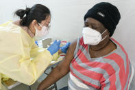 FILE - In this Jan. 23, 2021, file photo, registered Nurse Shyun Lin, left, administers Alda Maxis, 70, the first dose of the COVID-19 vaccine at a pop-up vaccination site in the William Reid Apartments in the Brooklyn borough of New York. An increasing number of COVID-19 vaccination sites around the U.S. are canceling appointments because of vaccine shortages in a rollout so rife with confusion and unexplained bottlenecks. (AP Photo/Mary Altaffer, Pool, File)