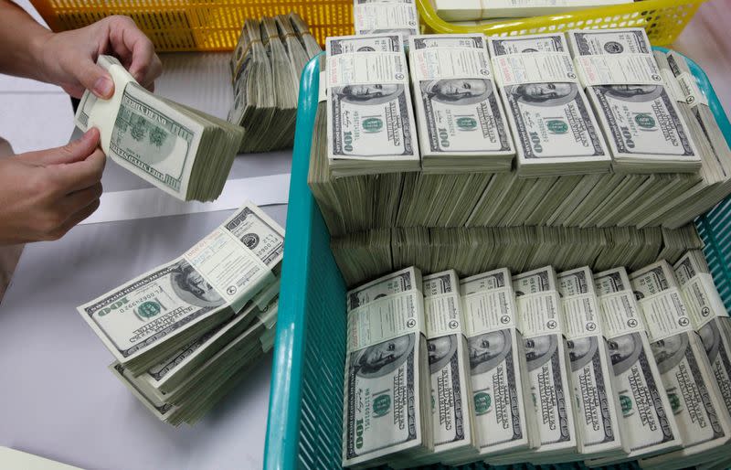 Foto de archivo. Un empleado bancario cuenta billetes de cien dólares estadounidenses en Kasikornbank